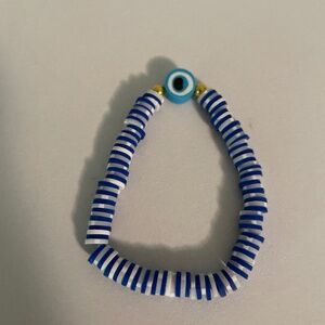 White and navy blue bracelet with an evil eye charm